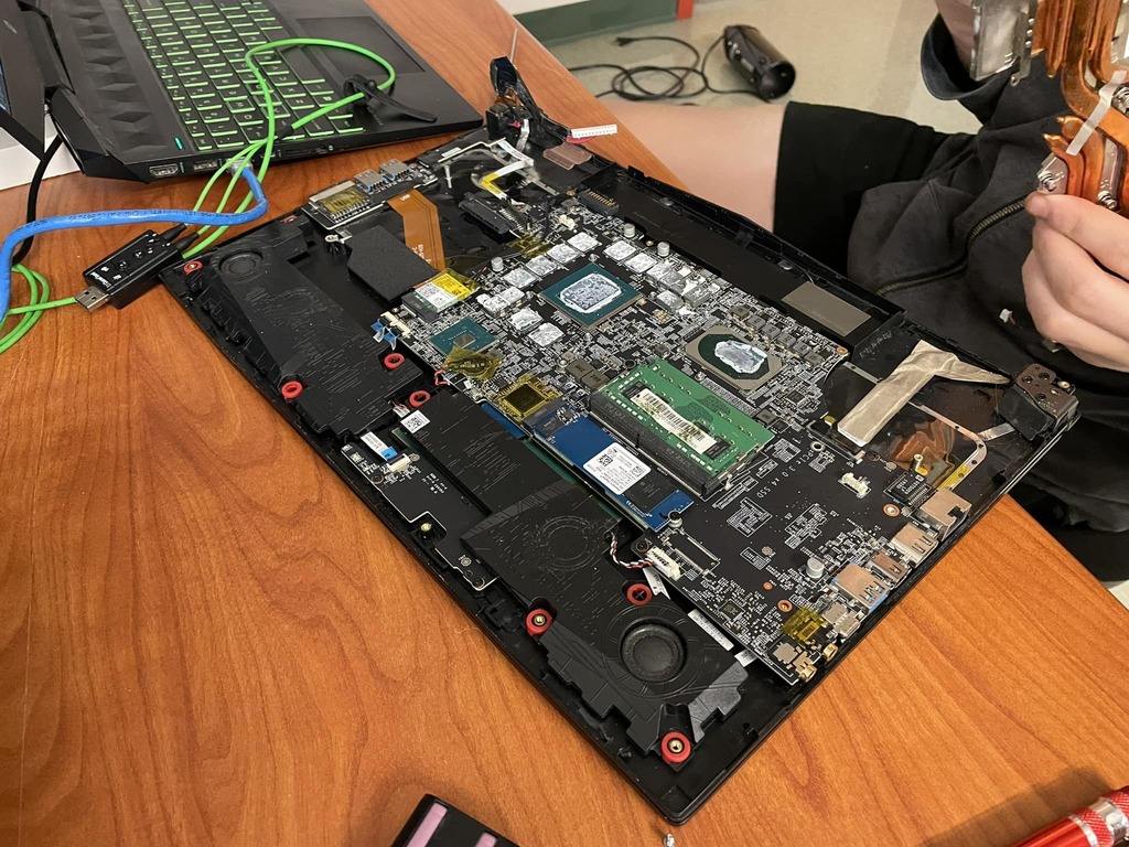 student taking apart a gaming laptop